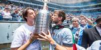 Os gremistas Pedro Geromel e Kannemann beijam a ta&ccedil;a da Libertadores conquistada em 2017  Foto: Reprodu&ccedil;&atilde;o/Site oficial Gr&ecirc;mio / Estad&atilde;o Conte&uacute;do