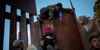 Imigrantes de Honduras que fazem parte de caravana a caminho dos EUA pulam cerca na fronteira do M&eacute;xico com os EUA na cidade mexicana de Tijuana 03/12/2018  REUTERS/Alkis Konstantinidis  Foto: Alkis Konstantinidis / Reuters