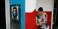 Jovem verifica celular em Cuba perto de um hotspot de internet 10,/8/2018 REUTERS/Tomas Bravo   Foto: Reuters