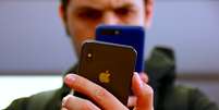 Pessoa fotografa iPhone 7 com outro celulae em foto ilustrativa em Sydney, Austrália
03/11/2017 REUTERS/David Gray  Foto: Reuters