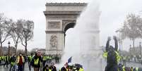 Manifestantes de coletes amarelos são atingidos por jato d'água da polícia perto do Arco do Triunfo, em Paris
01/12/2018
REUTERS/Stephane Mahe  Foto: Reuters