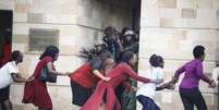 Mulheres são evacuadas durante atentado terrorista em Nairóbi, Quênia  Foto: EPA / Ansa - Brasil