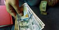 Trader exibe notas de dólar em corretora de câmbio. 3/12/2018. REUTERS/Fayaz Aziz.  Foto: Reuters