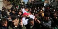 Corpo do adolescente palestino Hassan Shalabi, 14, morto durante protesto na fronteira entre Israel e Gaza, é carregado durante funeral na região central de Gaza.  Foto: Ibraheem Abu Mustafa  / Reuters