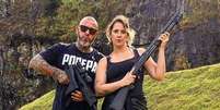 Henrique Fogaça posa ao lado da mulher, ambos segurando armas.  Foto: Instagram/@henrique_fogaca74 / Estadão
