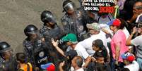 Alguns manifestantes empurraram os policiais, gritando "assassinos", e eles responderam usando spray de pimenta contra essas pessoas  Foto: Reuters / BBC News Brasil