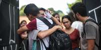 Estudantes e pais de alunos se emocionam ao se reencontrarem em frente ao portão da Escola Estadual Professor Raul Brasil, em Suzano, na Grande São Paulo, após o massacre  Foto: WERTHER SANTANA / Estadão Conteúdo