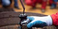 Trabalhador coleta amostra de óleo bruto em um poço de petróleo operado pela petrolífera estatal venezuelana PDVSA em Morichal, Venezuela. 28/07/2011. REUTERS/Carlos Garcia Rawlins  Foto: Reuters