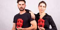 Gustavo Haddad e Bruna Magnez com as máscaras que representam a comédia e o drama: a vida corporativa como espelho da sociedade  Foto: Divulgação