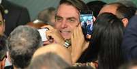 O presidente Jair Bolsonaro participa ao lado do ministro da Economia, Paulo Guedes, de cerimônia de sanção da lei do cadastro positivo, no Palácio do Planalto, em Brasília, nesta segunda-feira (8).  Foto: RENATO COSTA /FRAMEPHOTO / Estadão Conteúdo