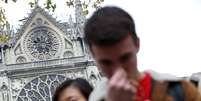 Pessoas rezam próximas à catedral de Notre-Dame após o incêndio  Foto: Yves Herman / Reuters