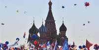 As pessoas celebram 1º de maio com bandeiras, balões, música e dança na Praça Vermelha, em Moscou  Foto: AFP / BBC News Brasil