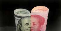 Nota de US$100 dólares com a imagem de Benjamin Franklin e uma cédula de 100 iuans com a imagem do líder chinês Mao Tse-Tung. 21/1/2016. REUTERS/Jason Lee  Foto: Reuters