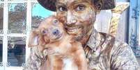 Yorge Lu&iacute;s Ruiz, artista de rua e imigrante venezuelano que trabalha como est&aacute;tua viva em Fortaleza, Cear&aacute;, com sua cachorrinha.  Foto: Instagram/@cachorrinhaartista / Estad&atilde;o