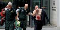 Homem ferido é ajudado por médico do lado de fora do Ministério do Interior do Reino Unido, em Londres
15/08/2019 REUTERS/Simon Dawson  Foto: Reuters