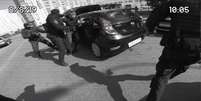 Amigo de Sergio é retirado do carro por atores vestidos como policiais  Foto: BBC News Brasil