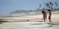 Banhistas em Conde, na Bahia; no Estado, órgão emitiu um alerta para que praias contaminadas com óleo sejam evitadas  Foto: REUTERS/Adriano Machado / BBC News Brasil