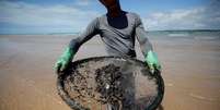 Homem atua na limpeza de derramamento de óleo na praia de Coruripe, Alagoas 
14/10/2019
REUTERS/Adriano Machado  Foto: Reuters