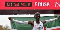 O queniano Eliud Kipchoge comemora após quebrar a barreira das duas horas na prova da maratona, em Viena (Crédito: HERBERT NEUBAUER / APA / AFP)  Foto: Lance!