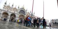 Turistas posam para foto na alagada Praça San Marco  Foto: ANSA / Ansa - Brasil