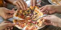 Pessoas comendo pizza  Foto: Getty Images / BBC News Brasil