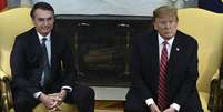 Bolsonaro e Trump em foto de março; os dois conversaram novamente por telefone nesta sexta-feira (20), onde o americano avisou que desistiu de sobretaxação  Foto: BRENDAN SMIALOWSKI/AFP / BBC News Brasil