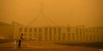 Faxineiro limpa pátio do Parlamento em Camberra: ar da capital australiana é afetado por queimadas  Foto: DW / Deutsche Welle