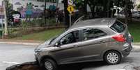 Um veículo caiu no buraco que se abriu após o asfalto ceder na Rua Carlos Comenale, no bairro da Bela Vista.  Foto: Fábio Vieira / Foto Rua / Estadão