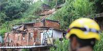 Militares do Corpo de Bombeiros interditam 12 residências com risco de desabamento após a queda de um muro e o deslizamento de um barranco no bairro Jardim América, em Belo Horizonte.  Foto: Ramon Bittencourt / O Tempo / Estadão Conteúdo