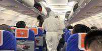 Funcionários da saúde conferem a condição dos passageiros em um avião na China; no Brasil ainda não houve necessidade de inspeção  Foto: David Stanway / Reuters