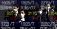 Pedestres utilizam máscaras em frente a painel de ações em Tóquio
26/02/2016
REUTERS/Yuya Shino  Foto: Reuters