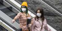 Mulheres vestem máscaras de proteção em Guangzhou, na China  Foto: EPA / Ansa - Brasil