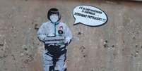 'Há uma epidemia de ignorância, devemos nos proteger', diz um mural pintado em Roma, na Itália  Foto: ANSA / Ansa - Brasil