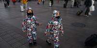 G&ecirc;meos usam m&aacute;scaras em mercado de rua em Pequim  Foto: Getty Images / BBC News Brasil