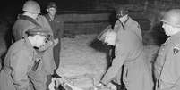Militares americanos do comando aliado examinam mala de talheres de prata, parte do saque alemão armazenado em uma mina de sal em Merkers  Foto: National Archives / BBC News Brasil