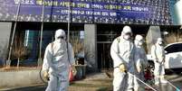 Funcionários de uma empresa de dedetização  desinfectam rua em frente à Igreja de Jesus o Templo do Tabernáculo do Testemunho, em Daegu
19/02/2020
Yonhap via REUTERS  Foto: Reuters