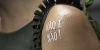 Foliã exibe tatuagem da campanha "Não é Não", que combate o assédio às mulheres, no desfile do bloco Comigo, na Avenida Ipiranga  Foto: BRUNO ROCHA/FOTOARENA / Estadão Conteúdo