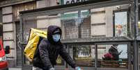 Entregador usa máscara de proteção em Milão, norte da Itália  Foto: ANSA / Ansa - Brasil