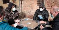 Homens com máscara de proteção jogam cartas em praça de San Fiorano, na Itália
27/02/2020
Marzio Toniolo/via REUTERS   Foto: Reuters