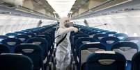 Homem aplica desinfetante em aeronave, dentro dos esforços para conter disseminação do coronavírus. 21/2/2020. REUTERS/Kham  Foto: Reuters