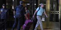 Casal de turistas norte-americanos deixa um hotel em Buenos Aires escoltado pela polícia em direção ao Aeroporto Internacional de Ezeiza  Foto: JUAN MABROMATA/AFP via Getty Images / BBC News Brasil