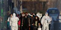 Agentes com roupa de proteção acompaham passageiros do lado de fora do aeroporto de Pequim
17/03/2020
REUTERS/Thomas Peter  Foto: Reuters
