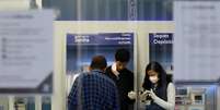 Funcionários de banco usando máscaras de proteção enquanto conversam com cliente, em meio à pandemia do coronavirus. 19/3/2020. REUTERS/Diego Vara   Foto: Reuters