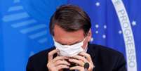 Presidente Jair Bolsonaro coloca máscara durante entrevista coletiva sobre coronavírus no Palácio do Planalto
18/03/2020
REUTERS/Adriano Machado  Foto: Reuters