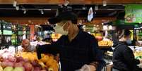 Homem faz compras em supermercado de Wuhan, na província de Hubei 26/3/2020 REUTERS/Stringer    Foto: Reuters