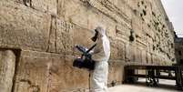 Agente sanitiza pedras do Muro das Lamentações no âmbito de medidas contra o coronavírus em Jerusalém
31/03/2020
REUTERS/Ammar Awad  Foto: Reuters