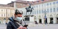 Mulher utiliza telefone celular e máscara de proteção em Turim, na Itália, em meio à pandemia de coronavírus 
27/02/2020
REUTERS/Massimo Pinca  Foto: Reuters