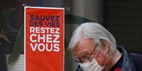 Homem com máscara de proteção passa por placa "Salve vidas, fique em casa" na França
01/04/2020
REUTERS/Charles Platiau  Foto: Reuters