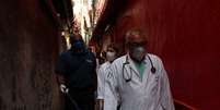 Profissionais de saúde caminham por favela de Paraisópolis, em São Paulo, após moradores terem contratado médicos particulares durante pandemia de coronavírus
30/03/2020
REUTERS/Amanda Perobelli  Foto: Reuters