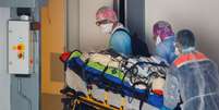 Trabalhadores da saúde transportam um paciente em uma maca no hospital Pontchaillou de Rennes, durante uma operação de transferência de pessoas infectadas com a doença Covid-19 do Hospital da Região de Paris para Britanny, na França. 01/04/2020. REUTERS/Stephane Mahe.  Foto: Reuters